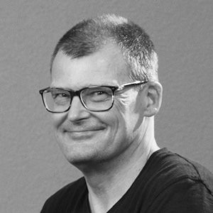 Rolf Wende General Manager bei PROJEDA. Das Porträt zeigt in in schwarz/weiss mit einem breiten lachen im Gesicht.